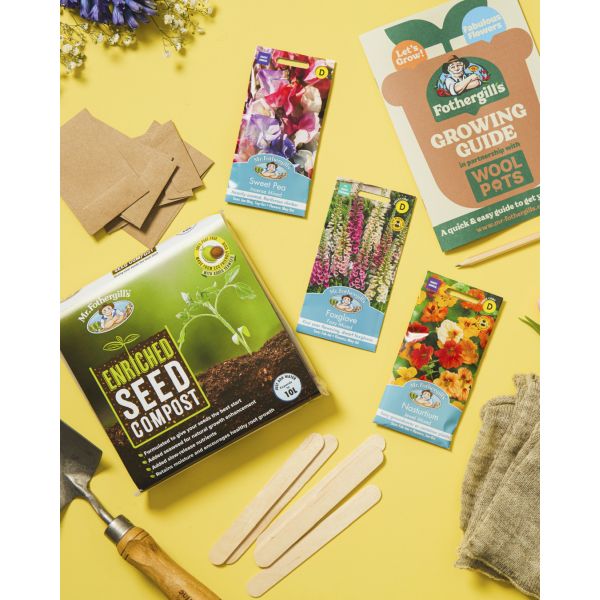 Gardening kit with seed compost, seed packets, and tools on a yellow background