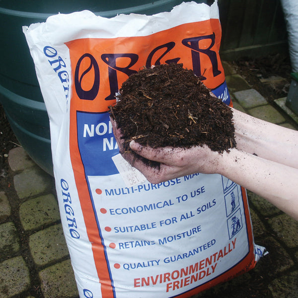 Person holding a handful of soil above an ORGAR organic fertilizer bag.