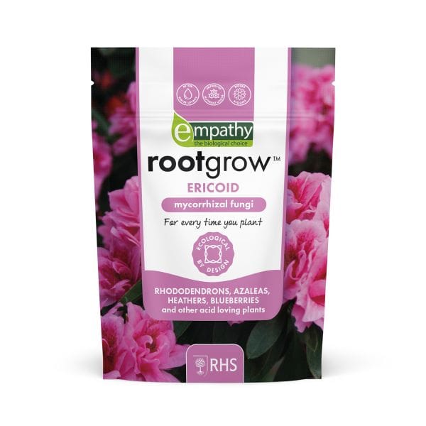 Rootgrow mycorrhizal fungi package with pink flowers in the background