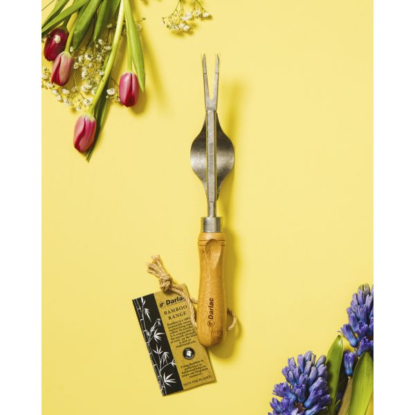 Gardening tool with wooden handle on a yellow background with flowers